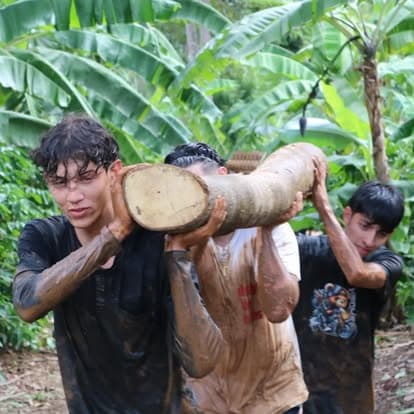 Jóvenes cargando un tronco en dinámica de campamento
