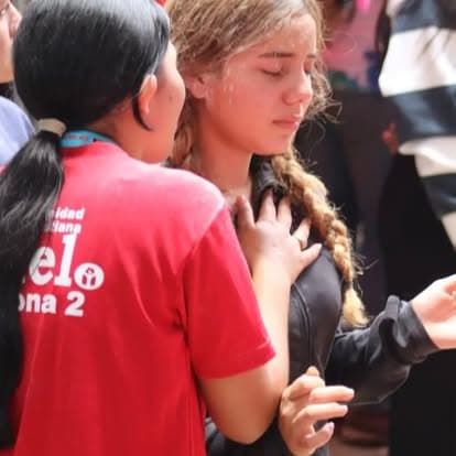Joven recibiendo oración durante actividad juvenil