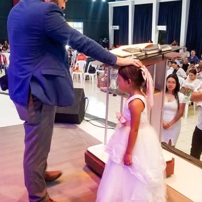 Niña recibiendo bendición en el altar