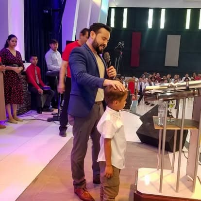 Niño recibiendo bendición en el altar